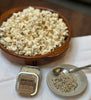 There is a bowl of pop corn with Omnivore 2 oz Tartufo Tin and a salt dish with Tartufo in it with a small silver spoon